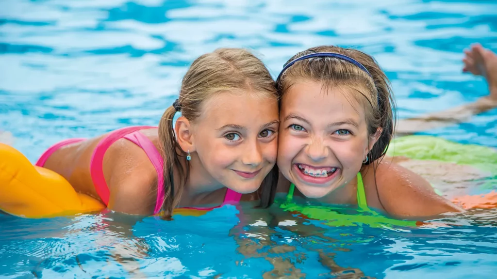 zwei Mächen im Wasser lachen in die Kamera